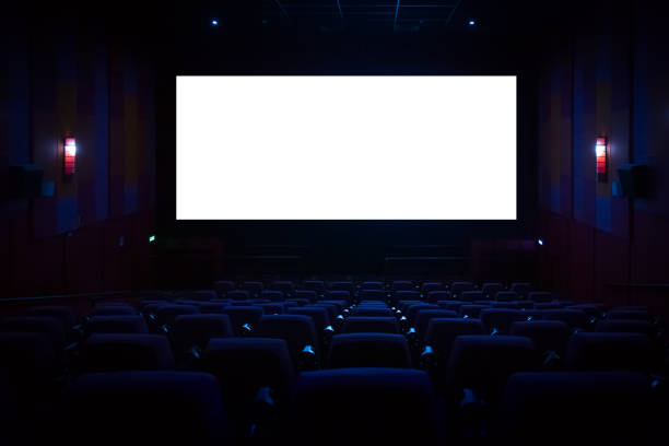 istock Empty cinema auditorium with empty white screen. Empty rows of theater or movie seats. 1454398588