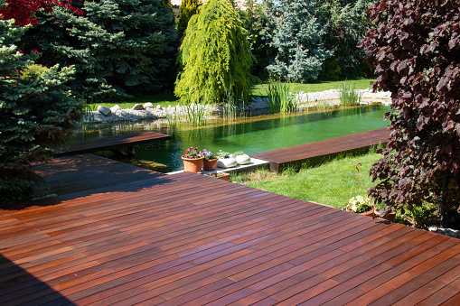 Natural home garden backyard with little pool lake, trees, plants and wooden decks, Ipe and cumaru decking