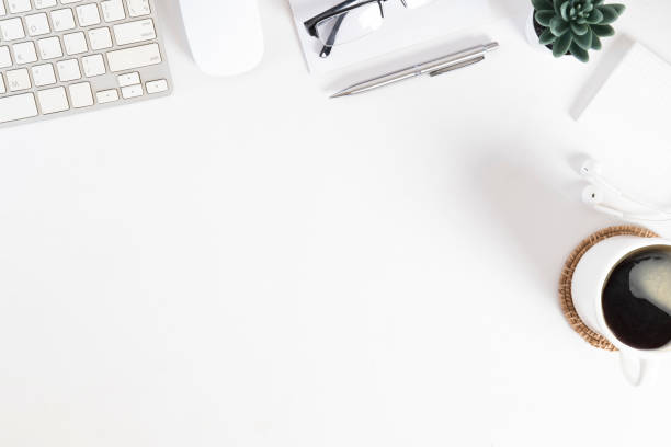 istock White office desk with wireless keyboard, coffee cup and notepad. Top view with copy space for your text. 1454405334