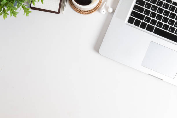 istock Top view of laptop computer, coffee cup, notebook and potted plant on white background. Copy space for your text. 1454405423