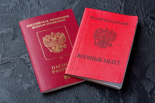 Russian documents passport and military ID on black background. Translation: Russian Federation Military ID.