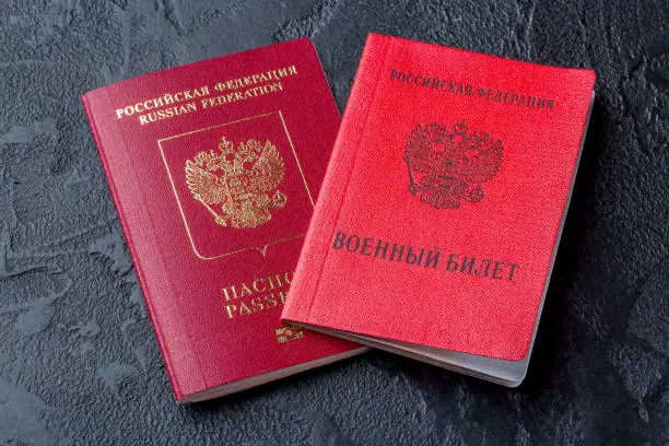 Russian documents passport and military ID on black background. Translation: Russian Federation Military ID.