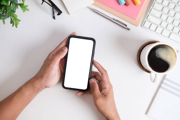 istock From above view of man hands holding mobile phone with white empty screen. 1454406138