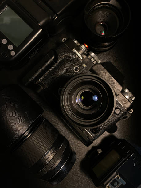 istock Top view of photographer workspace with digital camera, flash, and camera accessory on black table. 1454407509