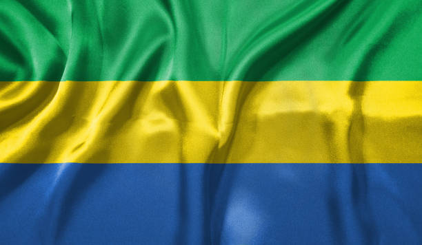 Gabon flag wave close up. Full page Gabon flying flag. Highly detailed realistic 3D rendering.