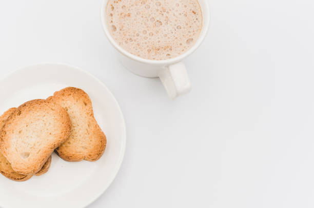 istock delicious hot vegan Cappuccino with foam in a white cup with crispy biscuits on a white tabletop 1454409987
