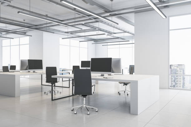 istock Perspective view on monochrome style open space office with modern computers on light tables, loft ceiling and city view background from panoramic windows. 3D rendering 1454410064