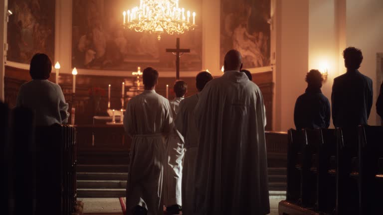 Liturgy In Church: Procession Of Ministers, Bearing Holy Cross to Altar, As Congregation Stands In Wonder. Christians Rejoice In Celebration Of Divine Mass. Hymns Praise God. Slow Motion Following