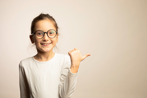 8 years old girl standing against color background.