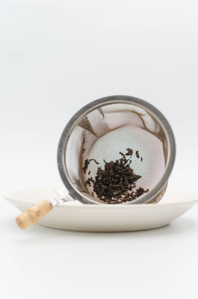 istock metal tea strainer with tea leaves on a white stoneware plate 1454411372