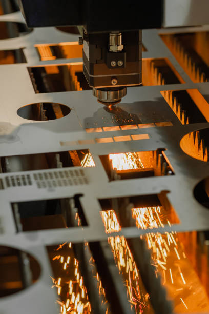 Laser cutting machine working with sheet metal with sparks Automatic cnc laser cutting machine working with sheet metal with orange sparks at factory, plant. Metalworking, industrial, equipment, technology, machining, manufacturing concept laser cutting metal stock pictures, royalty-free photos & images