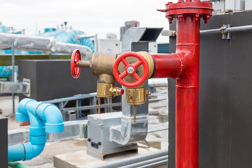 Red fire pump in front of concrete wall. fire safety pump on cement floor of concrete building. Deluge system of firefighting system. Plumbing fire protection.  High pressure fire safety pump.