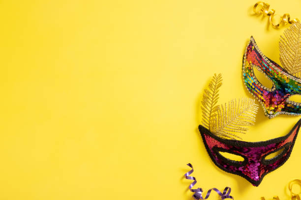 istock Festive face mask for carnival celebration on yellow background. Copy space. Carnival flat lay 1454414665