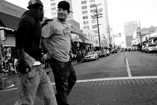 Los Angeles, United States – December 01, 2011: A greyscale closeup of two men crossing the street in Los Angeles Downtown US