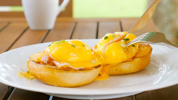 istock Female hands cuts egg Benedict with liquid egg yolk inside 1454415777
