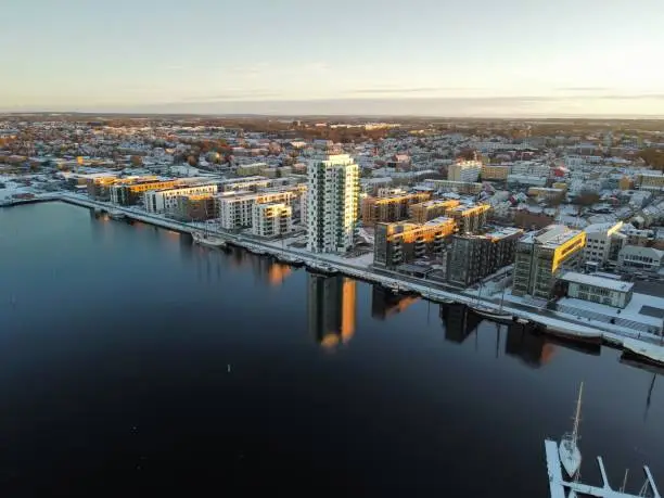 An aerial of snowy Karlstad cityscape reflecting in the water, Sweden