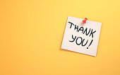 Thank You Lettering Written on Note Paper Sitting on Yellow Background