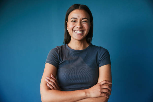 istock Young businesswoman laughing while standing against a blue backdrop 1454419004