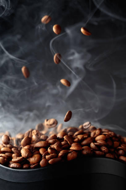 grãos de café fumegantes em movimento. - roasted macro freshness vertical - fotografias e filmes do acervo