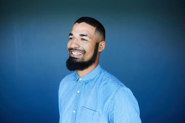 istock Smiling young businessman standing against a blue background 1454420338