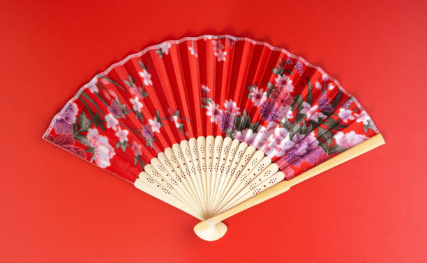 Painted hand fan with birds and flowers isolated on white background