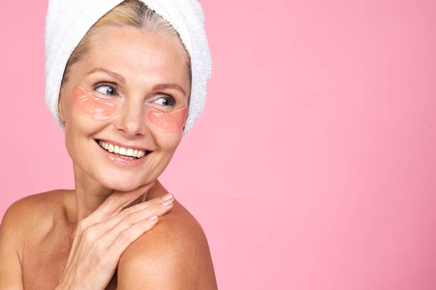 Smiling beautiful middle-aged woman, in a white towel on her head. stock photo