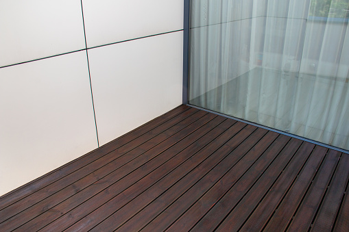 Pine wood deck, treated softwood decking terrace contrasting with white facade panels and large window, architecture detail of modern house design
