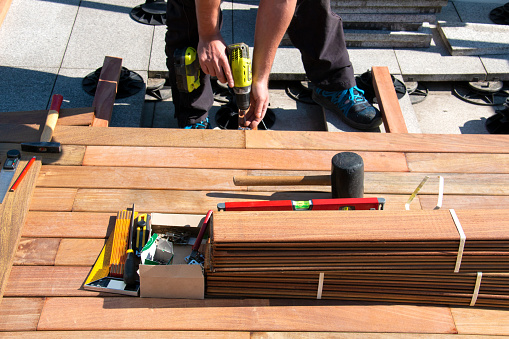 Carpenter building wooden deck construction, Ipe wood deck installation worker, decking hardwood terrace