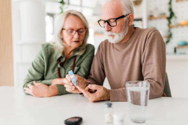 istock Senior couple using lancet on finger for checking blood sugar level by Glucose meter, Healthcare and Medical, diabetes, glycemia concept 1454427531