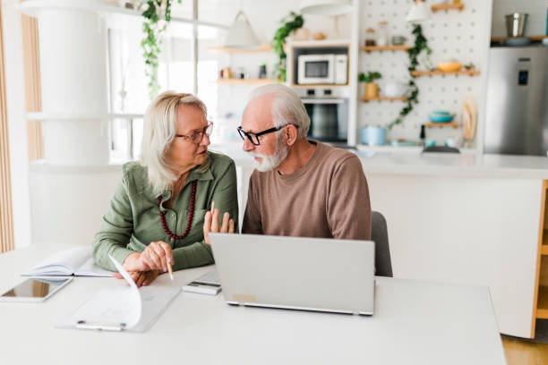istock Senior couple using laptop while planning their home budget, 1454428189
