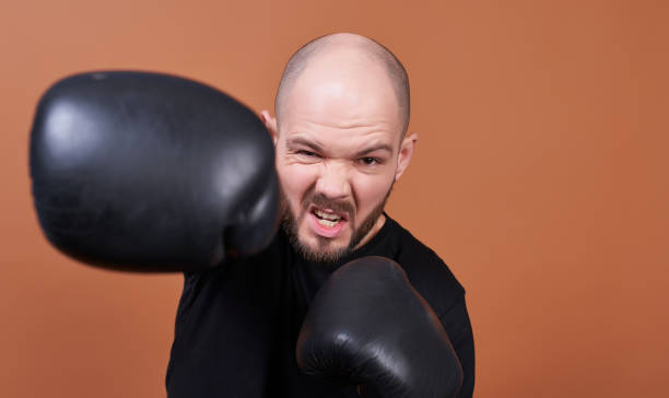 Aggressive young boxer hits with his right hand in the glove. stock photo
