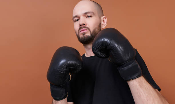 An image of a bearded boxer wearing black pairing gloves. stock photo