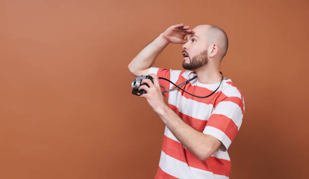 Handsome bearded guy takes a photo and looks somewhere to the side. stock photo
