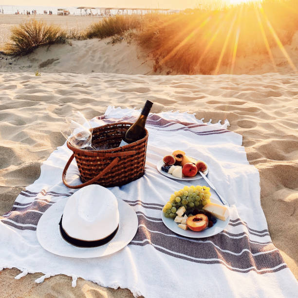 romantyczny piknik z winem na piaszczystej plaży o niesamowitym wieczornym zachodzie słońca - plaid still life tablecloth dinner zdjęcia i obrazy z banku zdjęć