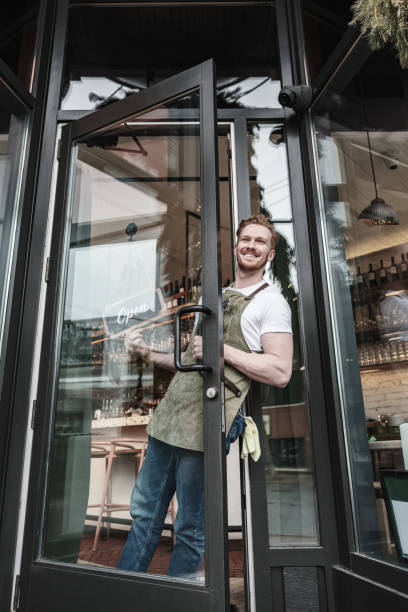 istock Young redhead barman opening the bar 1454431813