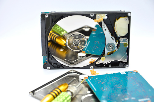 An open hard drive with a collage of photos on the surface of the drive. The concept of storing photos on electronic media.