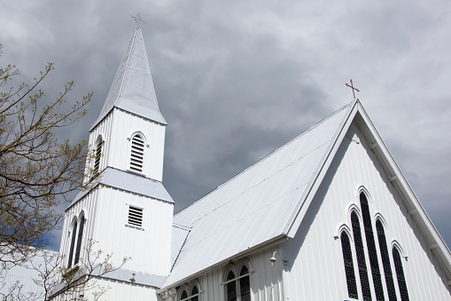 The dark heavy clouds over the wooden Presbyterian Church in Akaroa resort town (New Zealand).