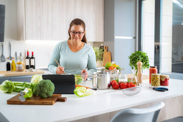 istock Hispanic woman blogging online virtual cooking class using digital tablet 1454434257