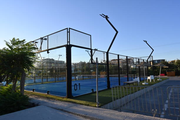 una pista azul cerrada para pádel con construcción creada por malla y las paredes traseras de vidrio. - racketball racket ball court fotografías e imágenes de stock