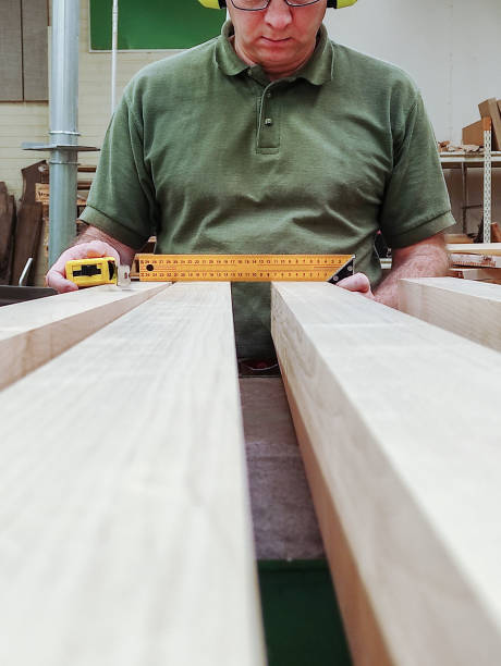 un hombre caucásico de 50 años es carpintero, mide y prepara bloques de madera. - herramienta triangular fotografías e imágenes de stock