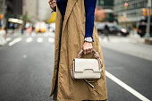 A woman with a smart watch holding a bag on the street of Manhattan during busy working week