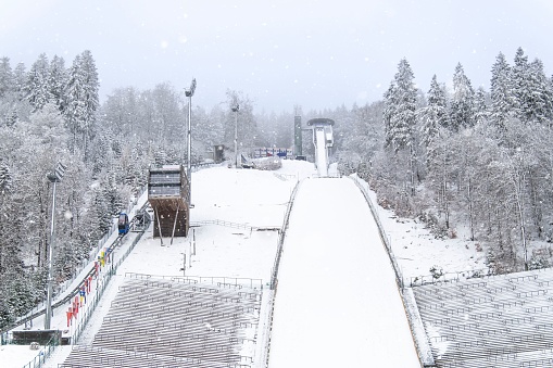 The Muehlenkopf ski jump in Willingen, Germany. The stands are deserted, it's snowing and it's optimal conditions for ski jumping.