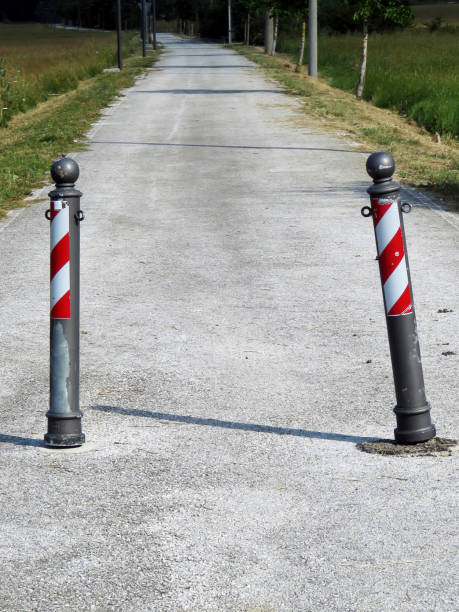 istock Old small columns limiting a public pedestrian road in the green fields 1454440235