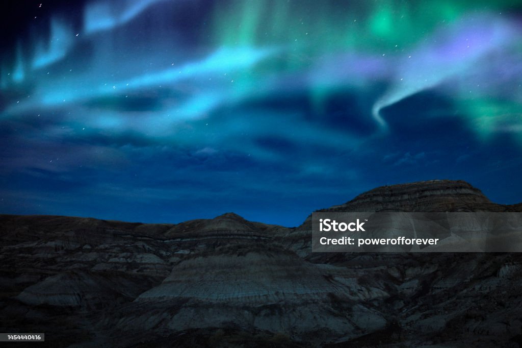 Aurora Borealis/Northern Lights Over the Landscape of the Canadian Badlands at Drumheller, Alberta, Canada Northern lights above the beautiful landscape of the Canadian Badlands in Drumheller, Alberta, Canada. Alberta Stock Photo