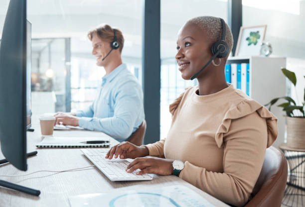 istock Black woman, customer support and service with a smile working for digital call center or online telemarketing business. Crm consultant at office desk, helping customer and searching pc for solution 1454441794