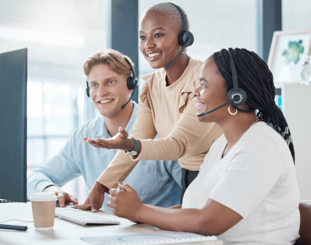 istock Training, teamwork and call center team in office on computer working together. Customer service, diversity and coaching manager, leader or employee helping, advise or teaching in company workplace. 1454441809