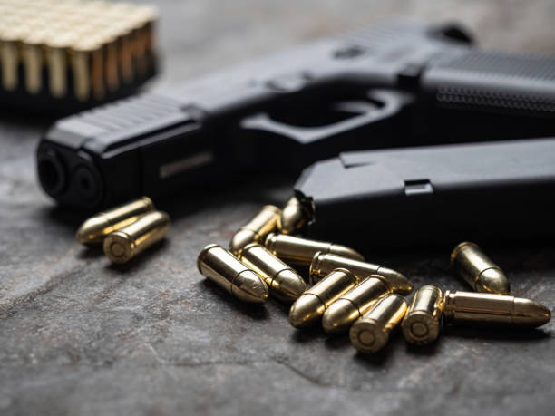 istock Hand gun with ammunition on dark background. 9 mm pistol. 1454441818