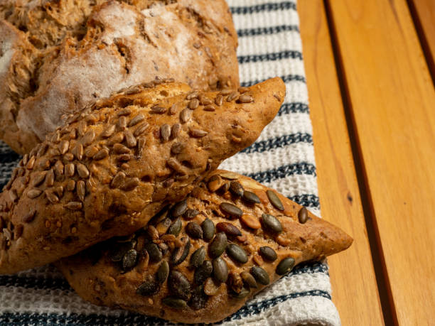 istock Dark bread and buns on a wooden background. Bakery products with grains. 1454442834