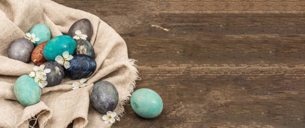 huevos de pascua en cesta de mimbre y cereza en flor sobre fondo de madera vieja. tarjeta de felicitación festiva - easter egg isolated remote frame fotografías e imágenes de stock