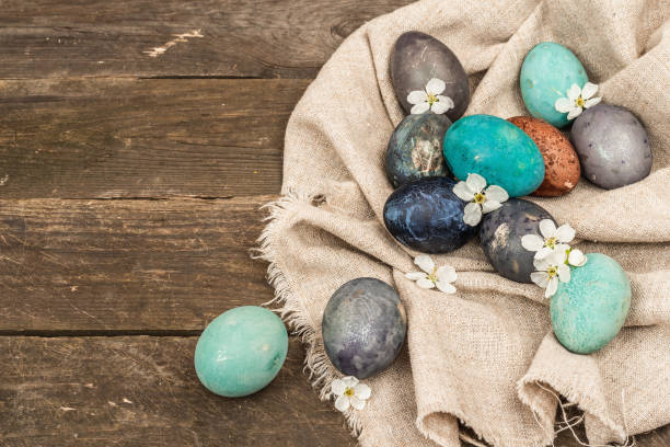 huevos de pascua en cesta de mimbre y cereza en flor sobre fondo de madera vieja. tarjeta de felicitación festiva - easter egg isolated remote frame fotografías e imágenes de stock